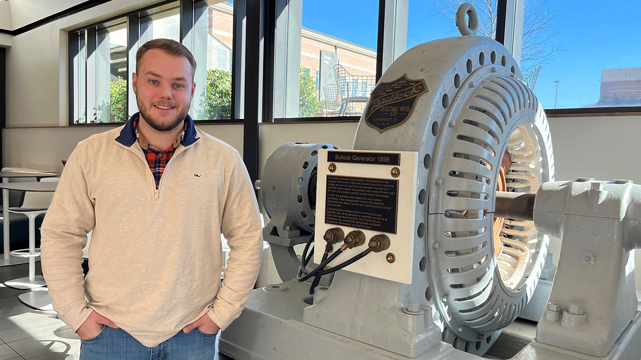 Ethan Hughes, pictured beside the college's legendary Bullock generator, hopes to parlay three co-op rotations at Southern Company into a career within the utilities industry.