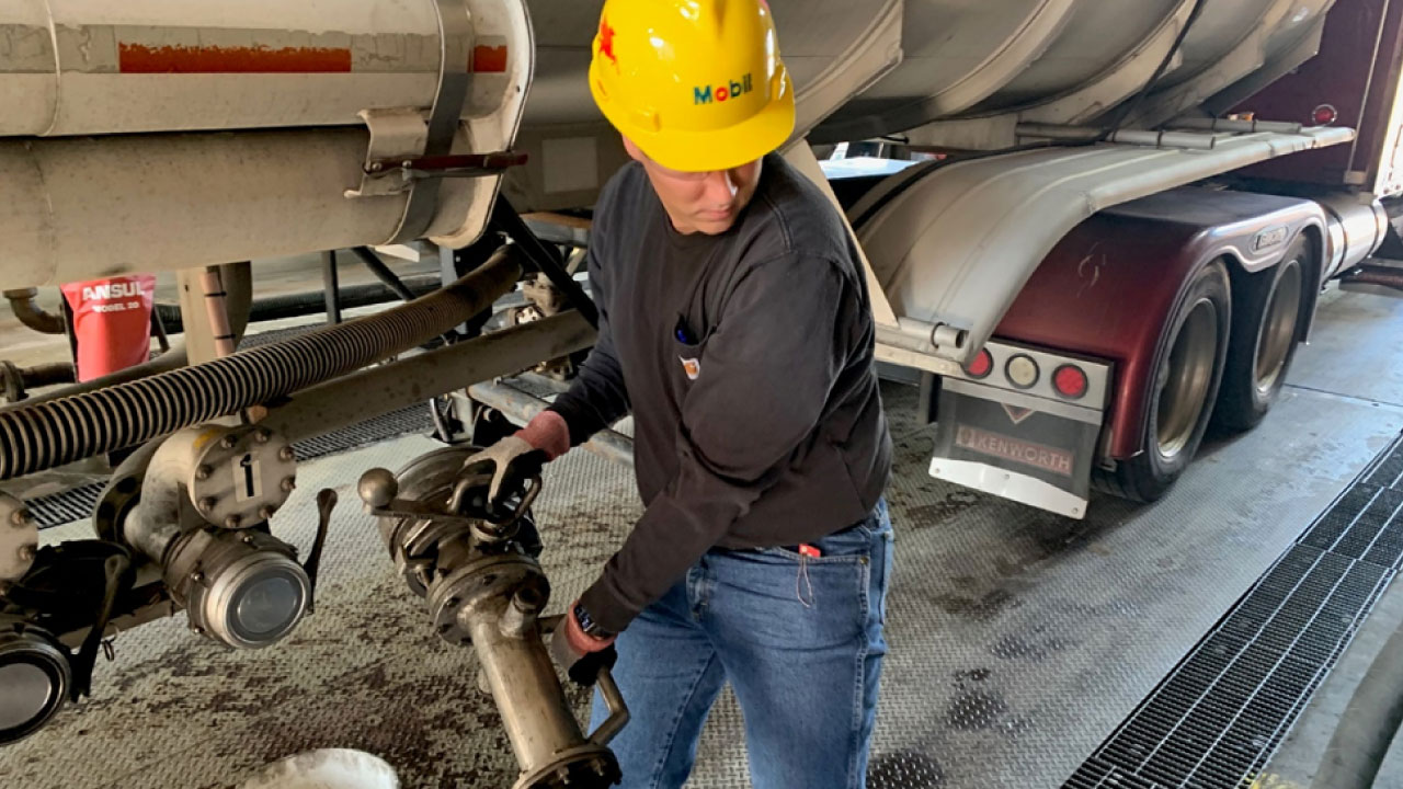 A worker wearing a yellow hard hat labeled 