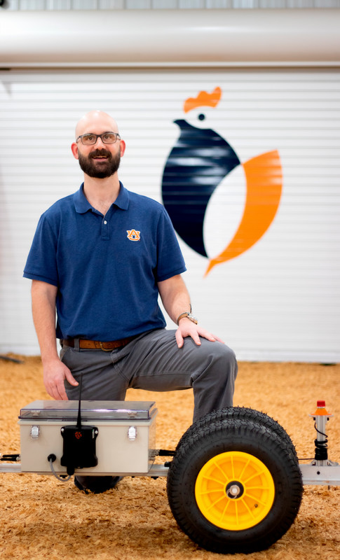 Dr. John Linhoss at National Poultry Technology Center posed in front of device for his research