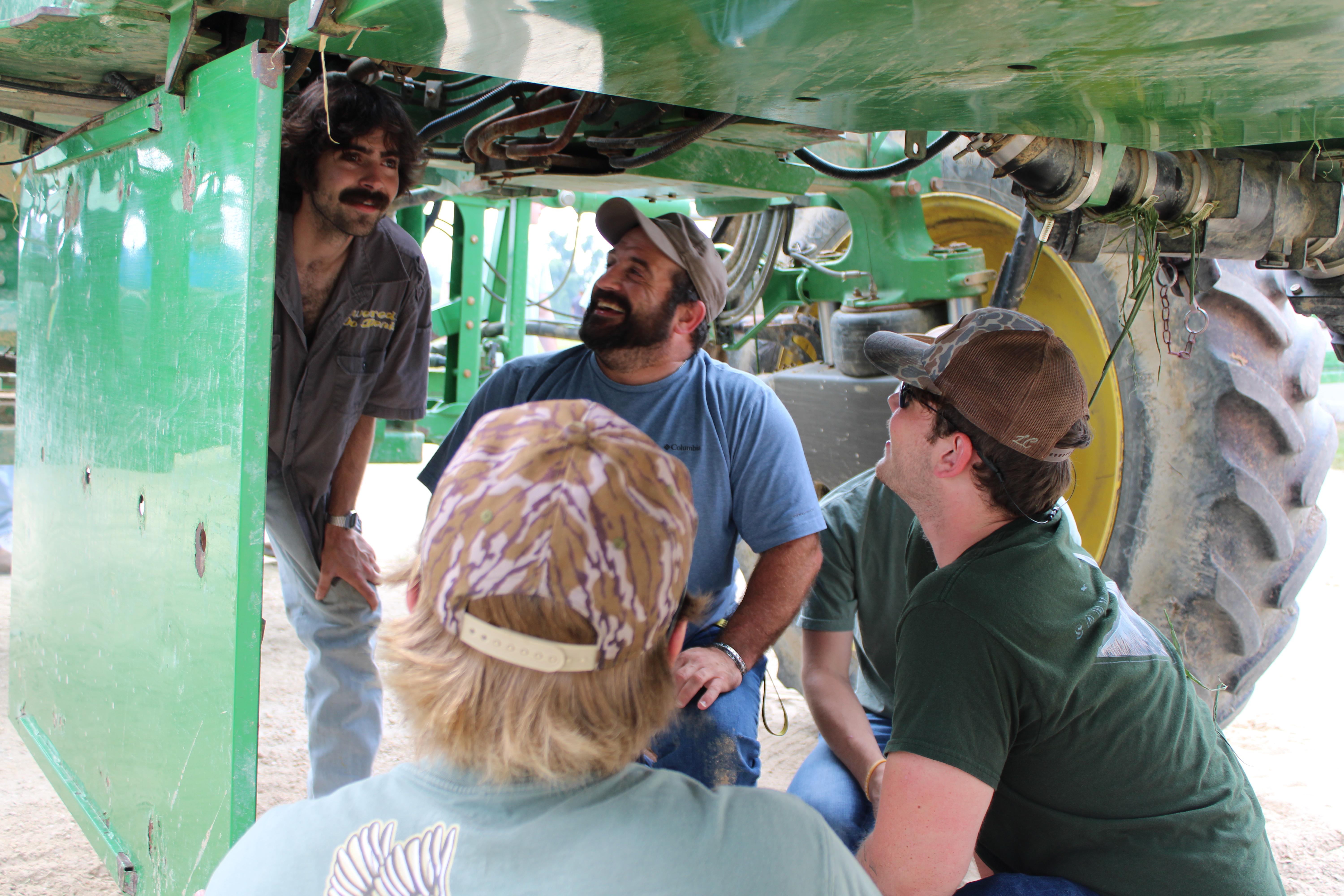 Students looking at the bottom of a tractor