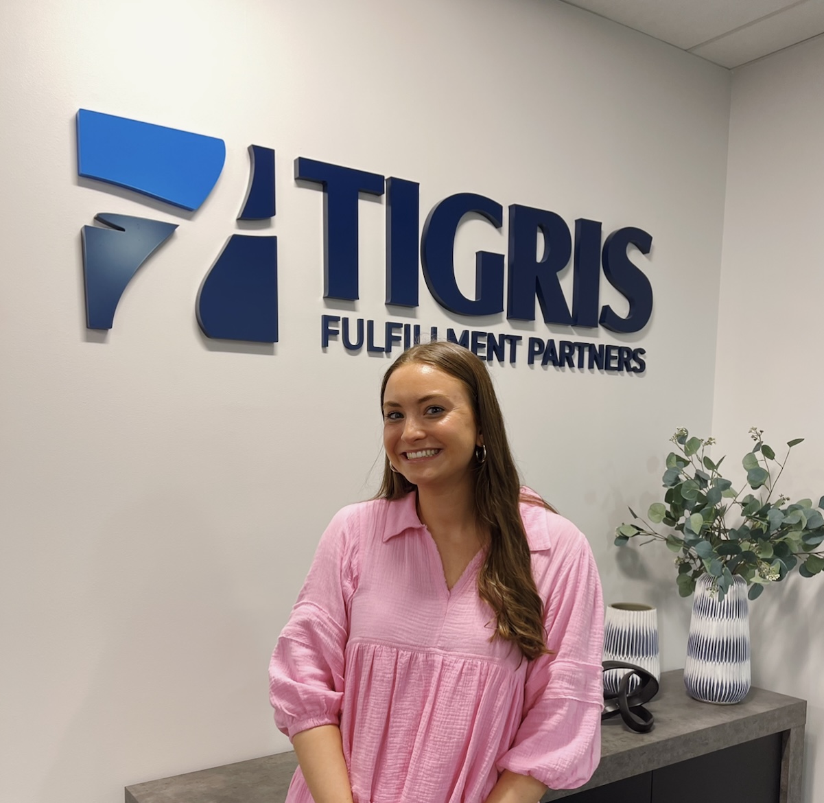 intern in front of sign