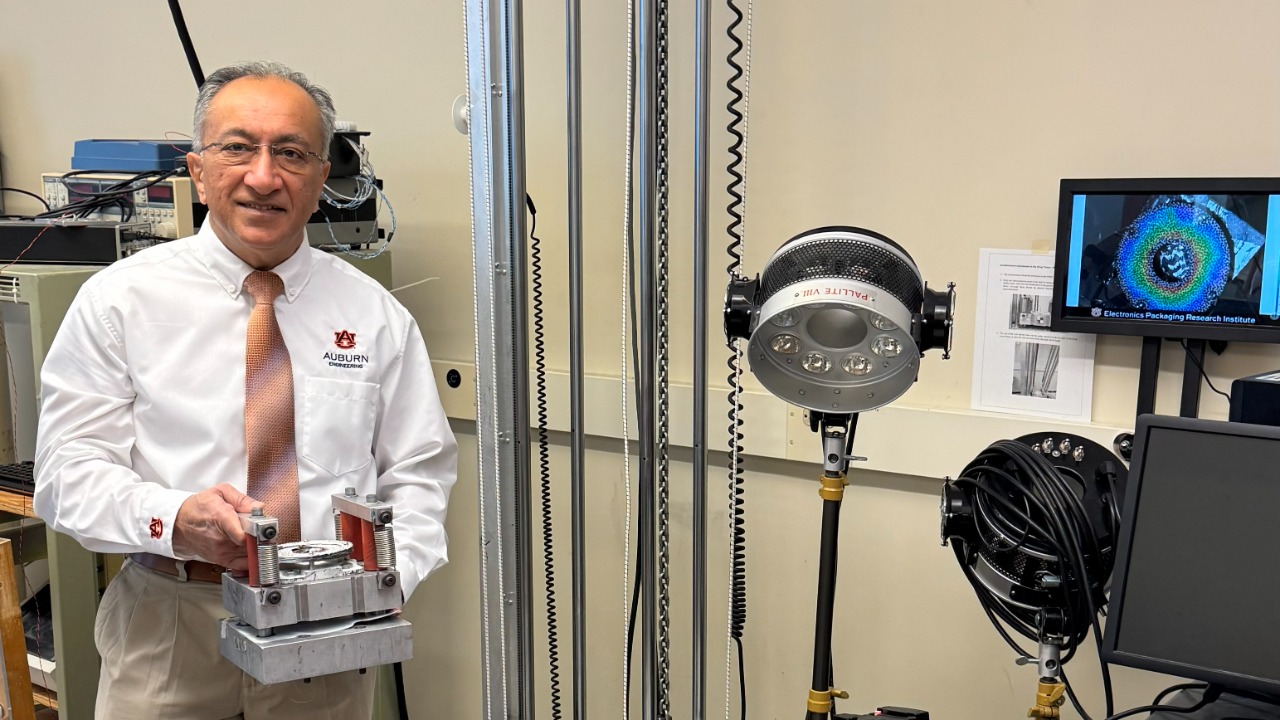 Pradeep Lall displays a high-g test assembly with real-time digital image correlation measurements for training of AI reliability models.