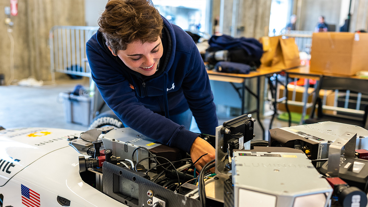 Stephanie Meyer inspects Auburn's Dallara AV-21 autonomous race car before the first Indy Autonomous Challenge in 2021.