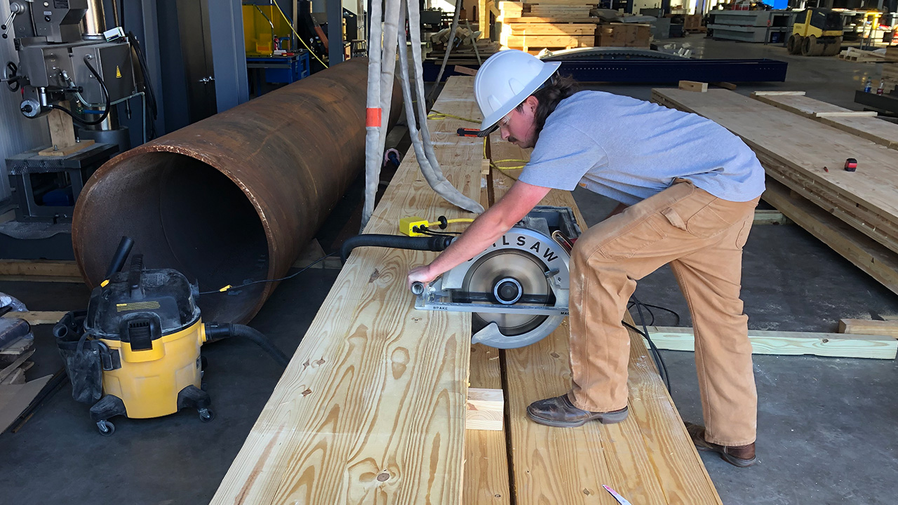 man using saw on timber