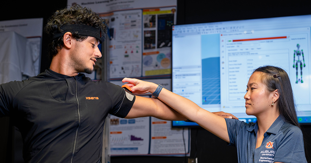 AUBE Lab graduate student Haley Duncan adjusts a wearable motion capture sensor on fellow graduate student Matt Ferreira-Shornack.