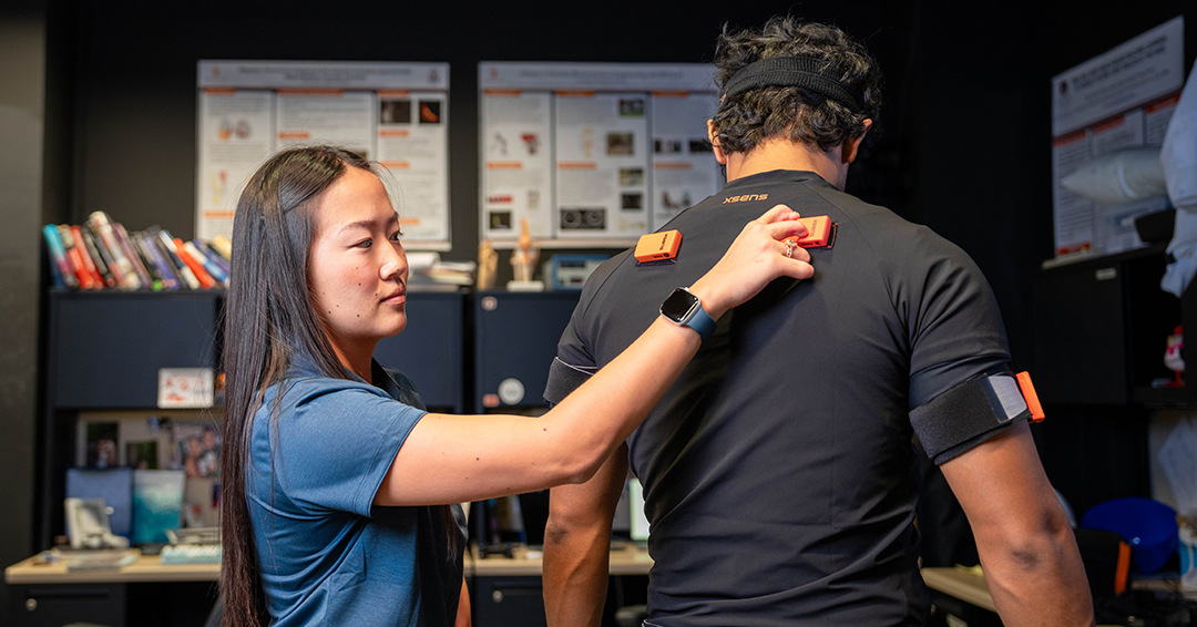 Haley Duncan adjusts a wearable motion capture sensor on fellow AUBE Lab graduate student Matt Ferreira-Shornack.