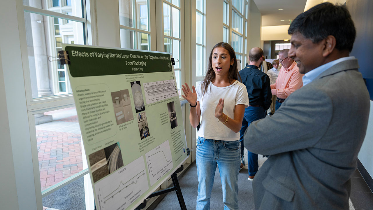 Finley Gray, a junior in aerospace engineering, discusses her summer research, "Effects of Varying Barrier Layer Content on the Properties of Multilayer Food Packaging," with Allan David, the college's associate dean for research.