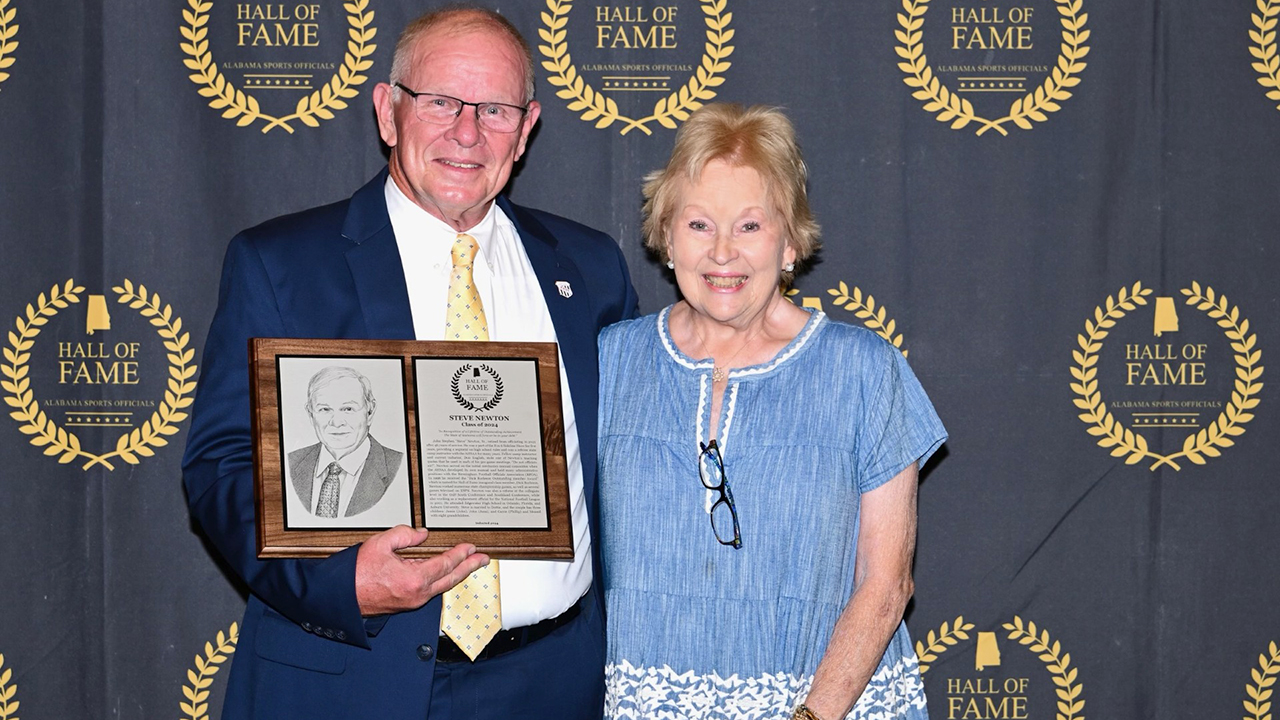 A man and a woman pose for a photo holding an award