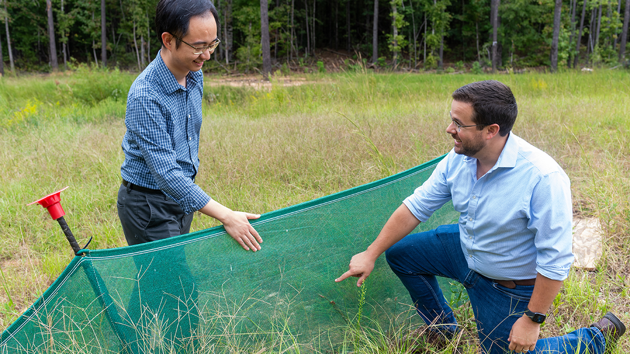 two men in front of geotextile fence