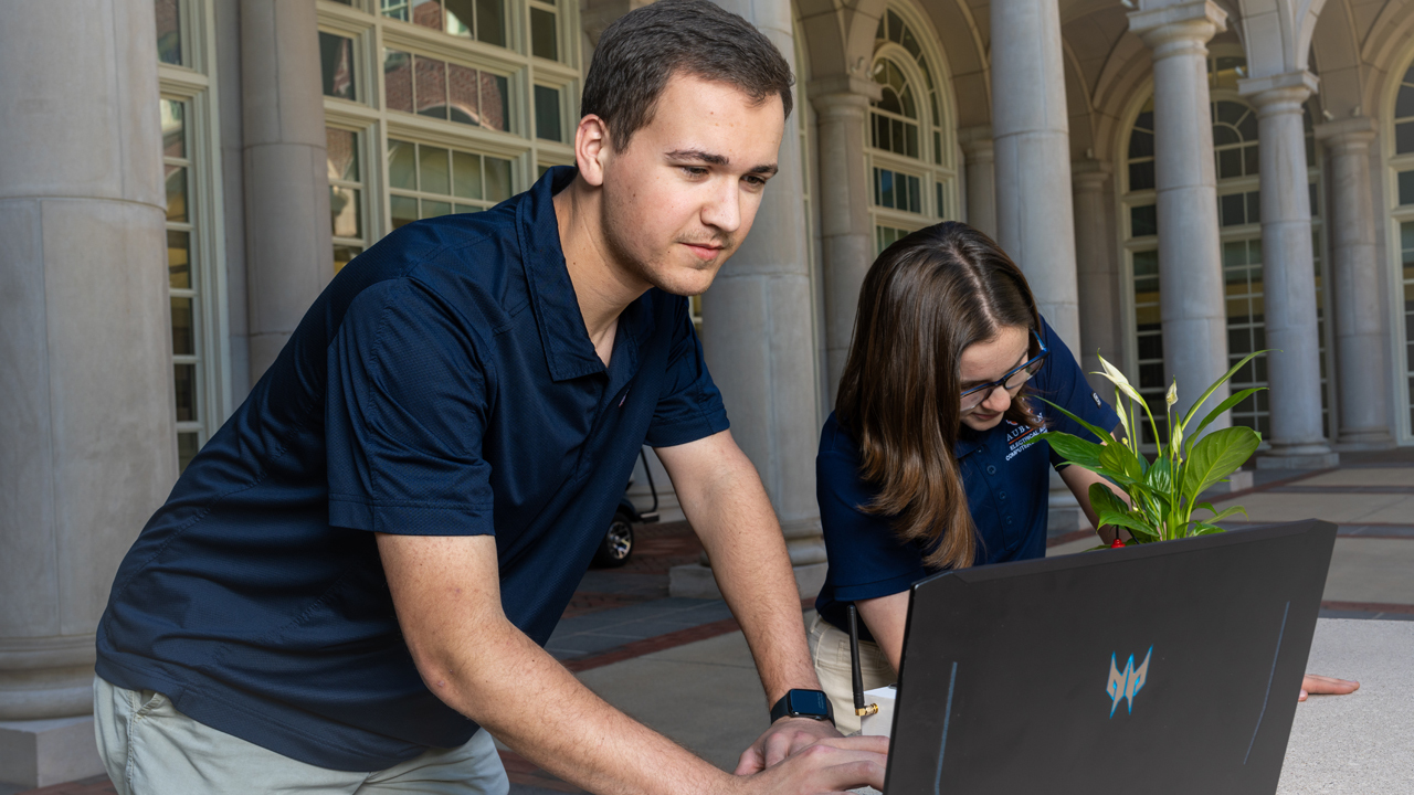 Elijah Parker and Katie Wolfe plug statistical data from the Distributed Network for Agricultural Monitoring (DNAM).