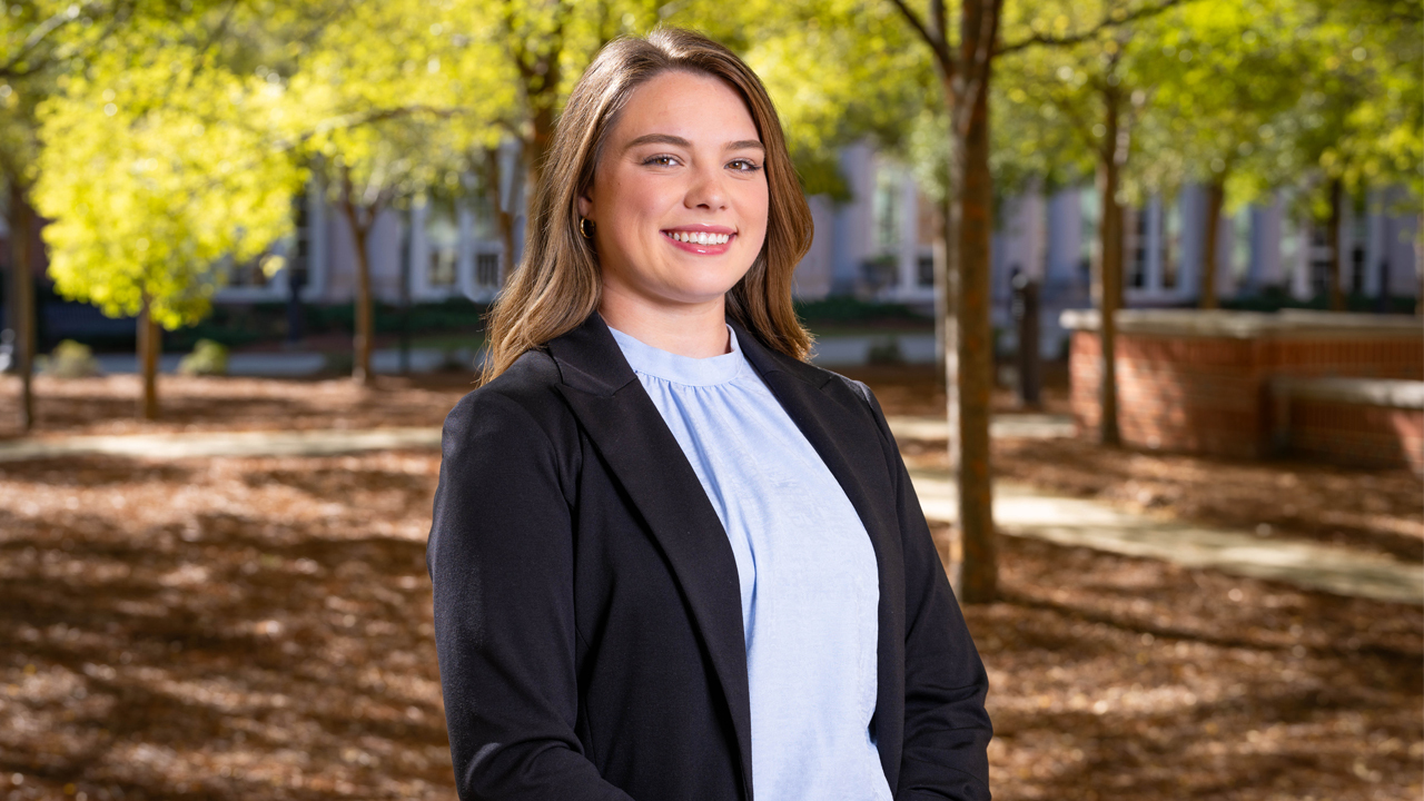 a woman poses for a photo outside