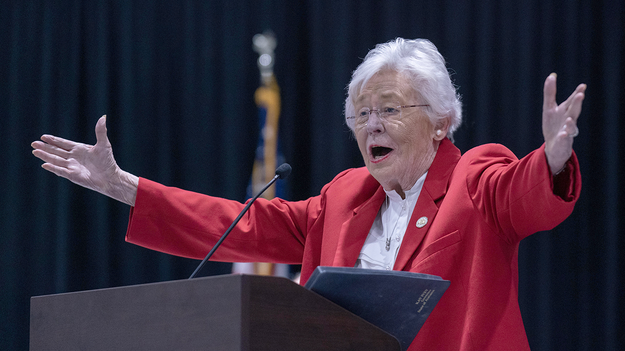 woman in red jackets holds arms out