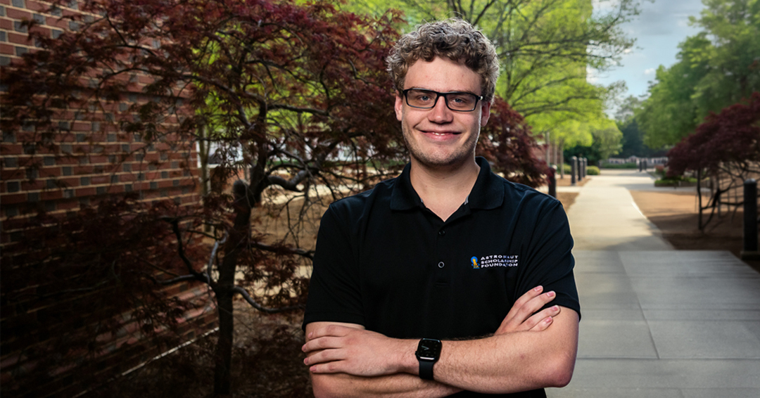 Auburn Engineering student Eirik Mulder stands outdoors on campus with arms crossed, wearing a black polo shirt.