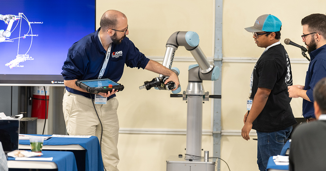 An ICAMS researcher demonstrates advanced manufacturing technology, highlighting real-time data integration and machine connectivity.