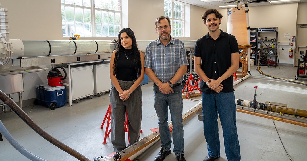 Maria Luisa Lobo, Jose Vasconcelos and Luiz Morgado stand beside experimental pipeline systems in an Auburn Engineering laboratory.