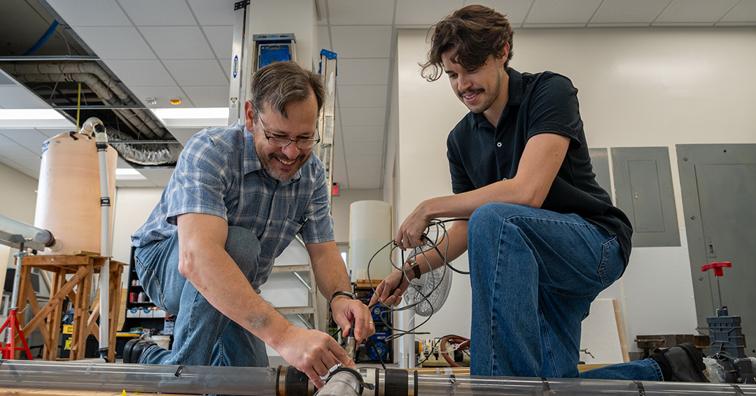 Jose Vasconcelos, left, and civil and environmental engineering master’s student Luiz Morgado work on an experimental pipeline system in an Auburn Engineering laboratory.