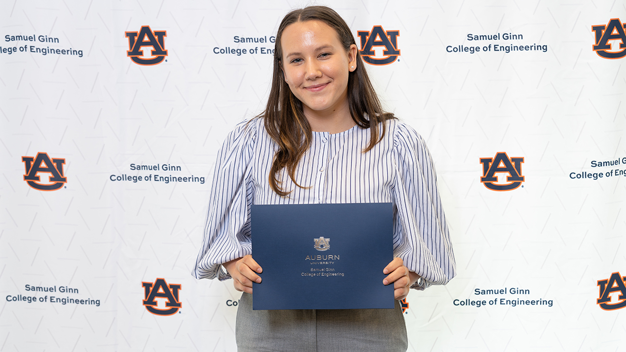 Woman holds awards with white background
