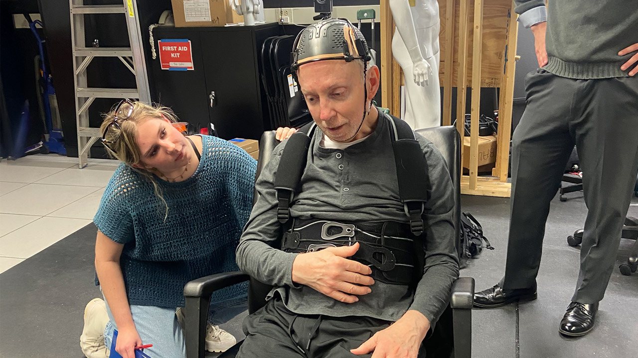 A student checks on Larry Green after he is fitted with a brace.