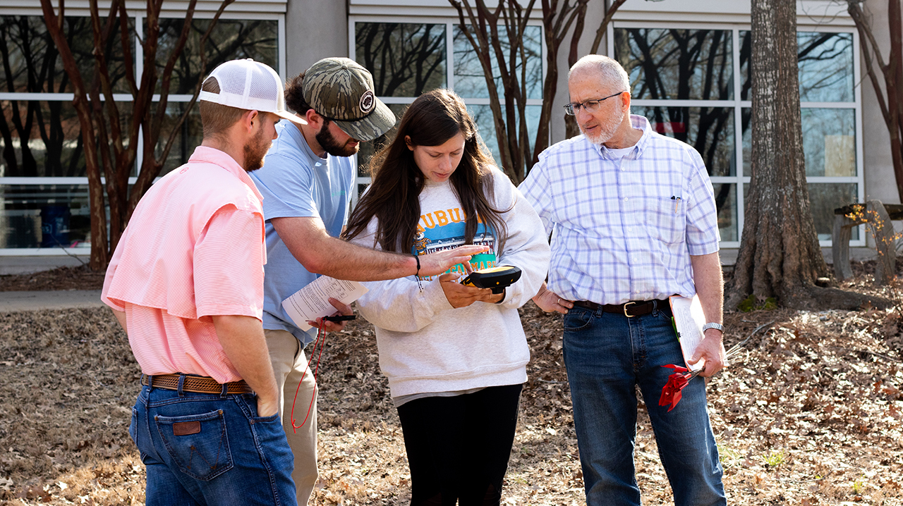 Students and professor Dr. Dougherty outside conducting a lab