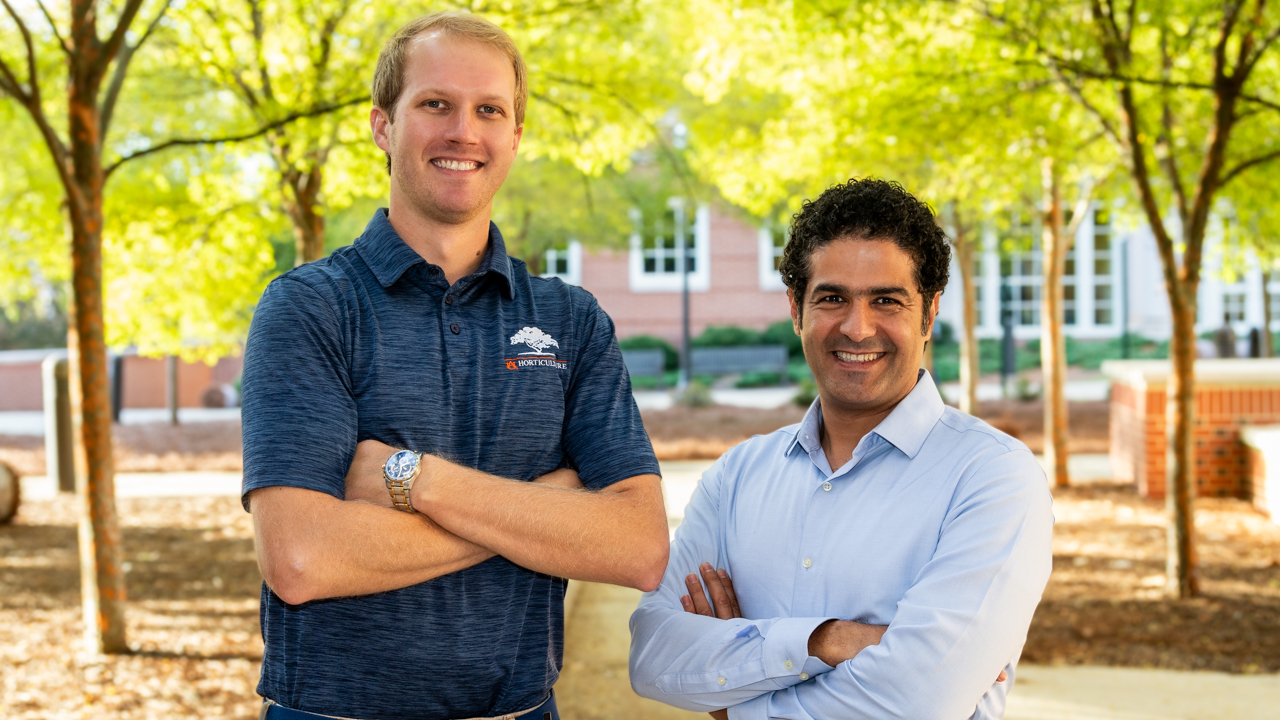 two men stand in yard for photo