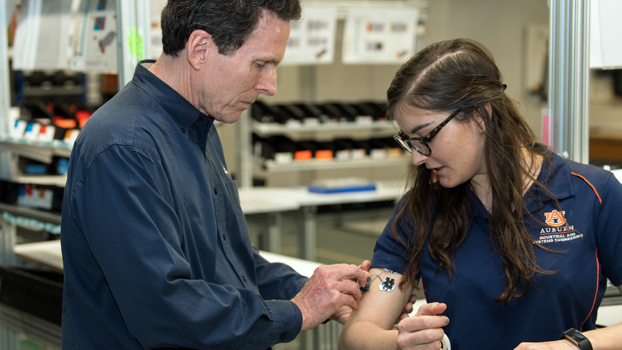 professor attaches device to female student