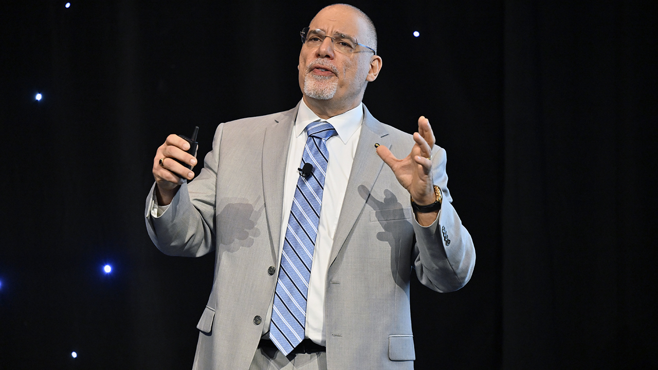 man on stage giving lecture