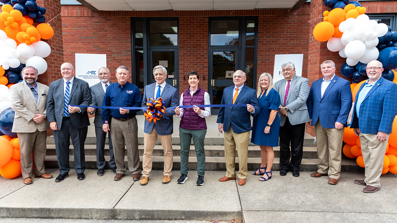 several people stand behind a ribbon for a grand opening