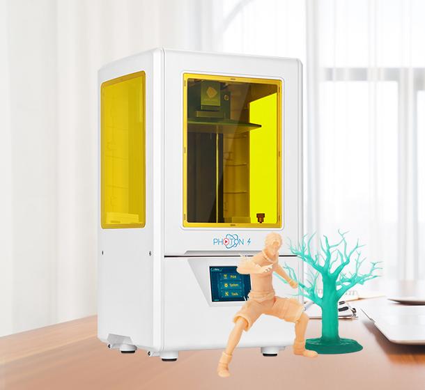 3d printer medium size is yellow and white. It also has printed examples of what it is capable of like a person and a tree.