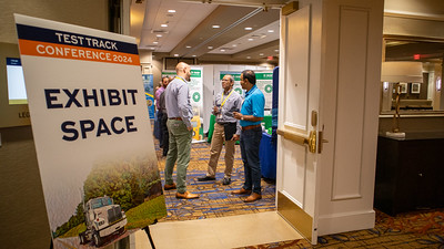 Conference attendees networking in the exhibit area at the NCAT Test Track Conference